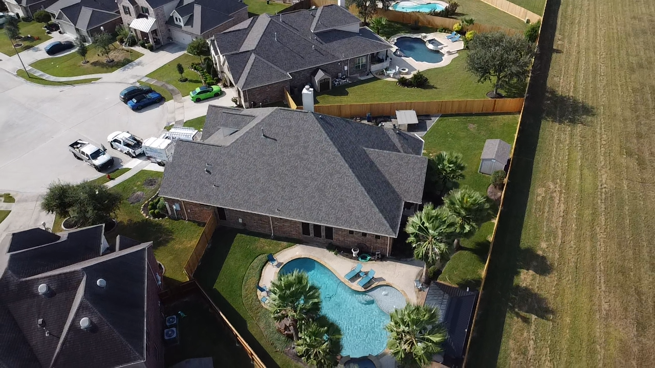 An aerial view of a house with a pool in the backyard.