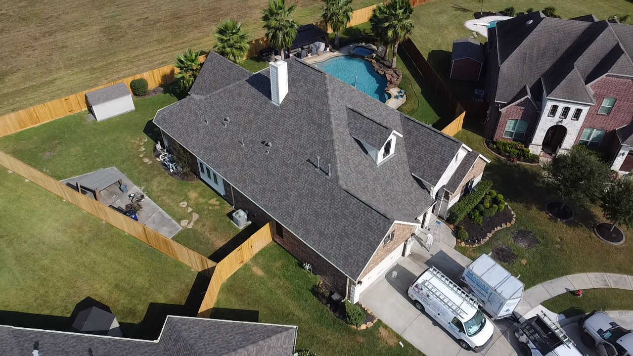 An aerial view of a house with a pool in the backyard.