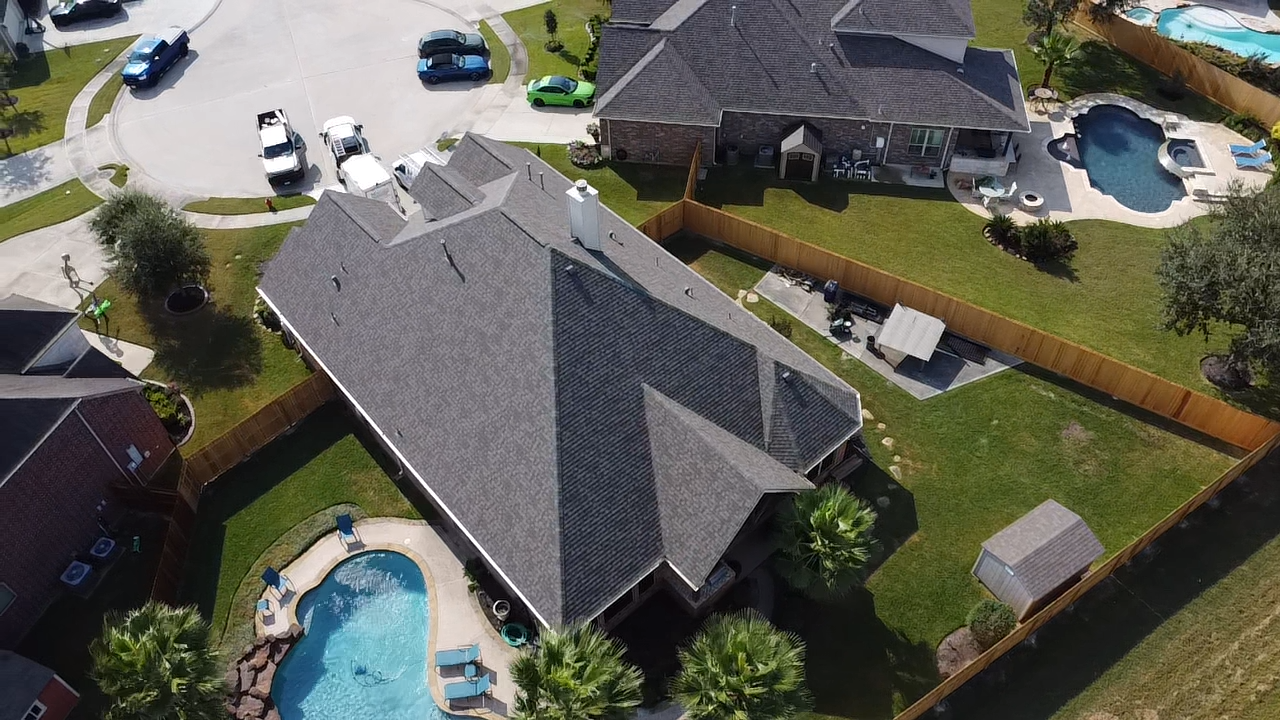An aerial view of a house with a pool in the backyard.