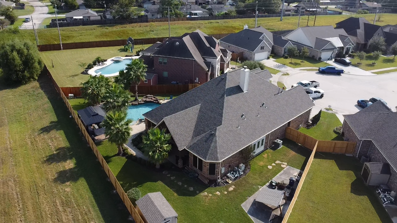 An aerial view of a house with a pool in the backyard