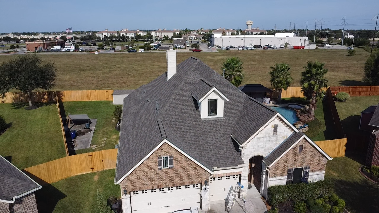 An aerial view of a house with a gray roof
