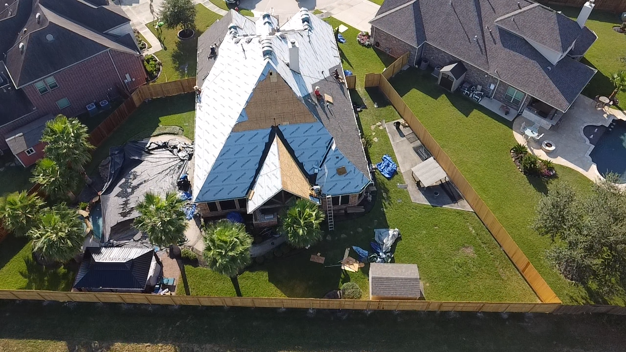 An aerial view of a house under construction in a residential area.