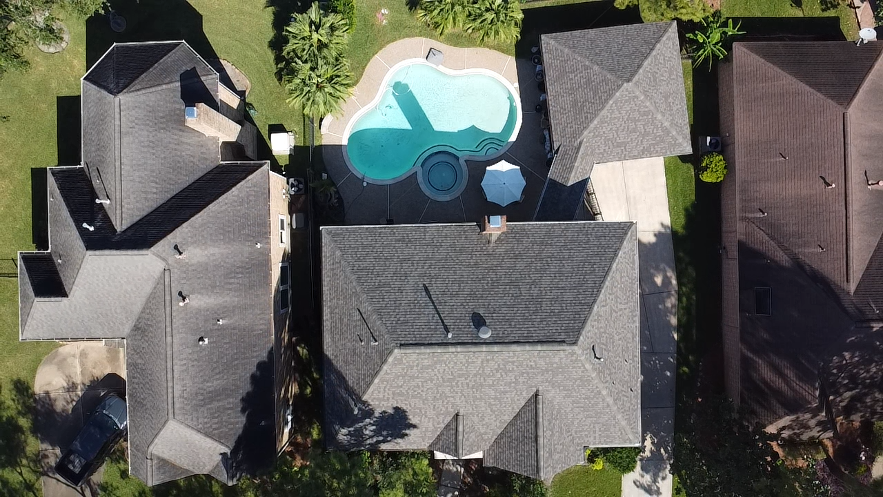 An aerial view of a house with a pool in the backyard.