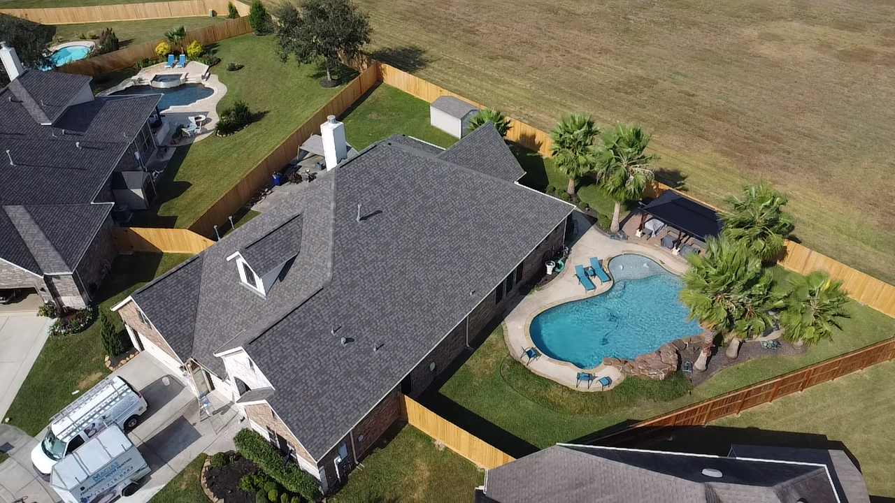 An aerial view of a house with a pool in the backyard.
