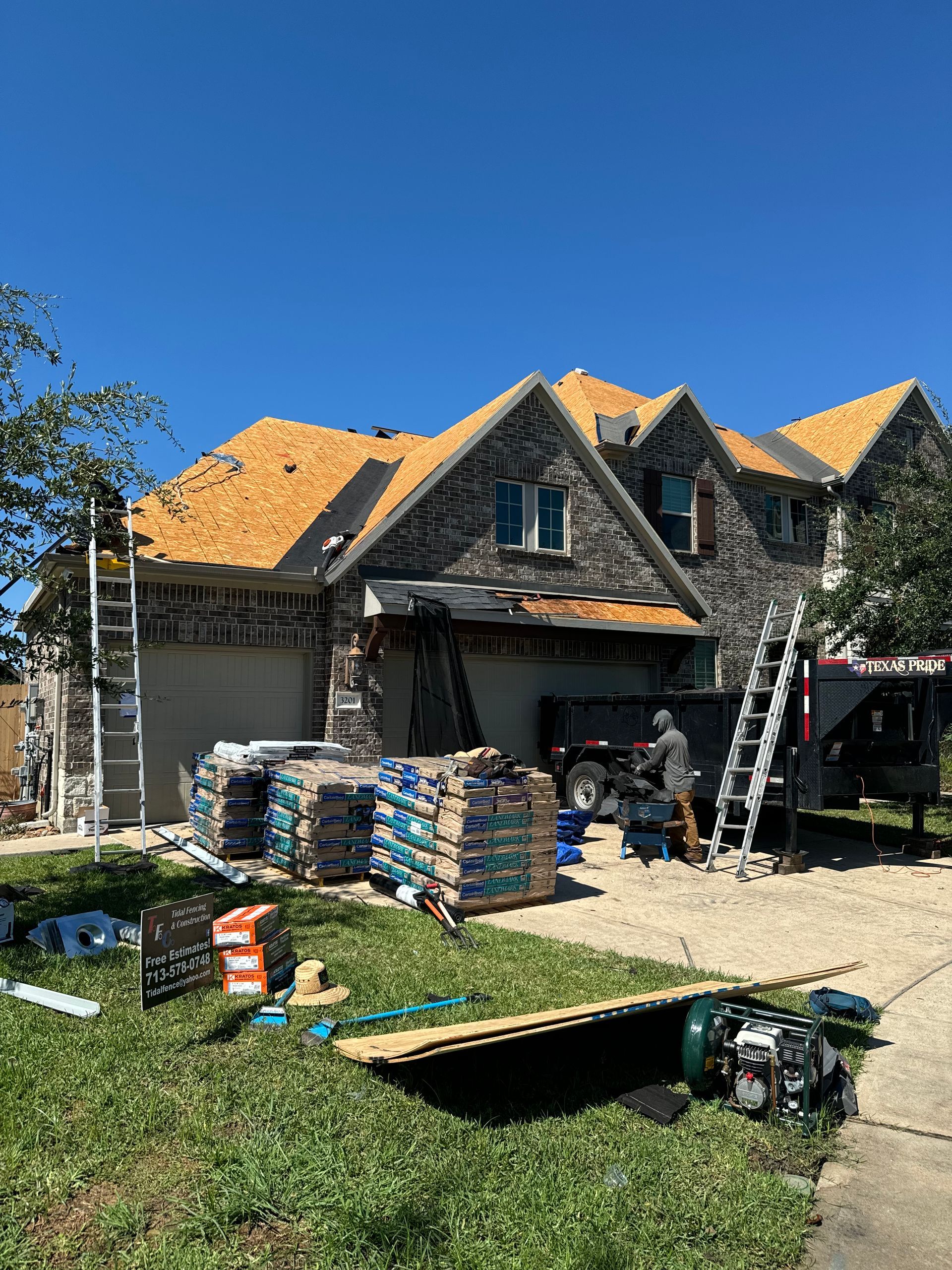 Exterior corner of a house with gray siding, white trim and gutters, black-framed window, and dark roof.
