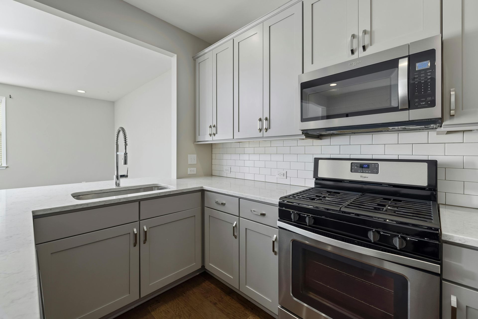 A kitchen with stainless steel appliances and white cabinets