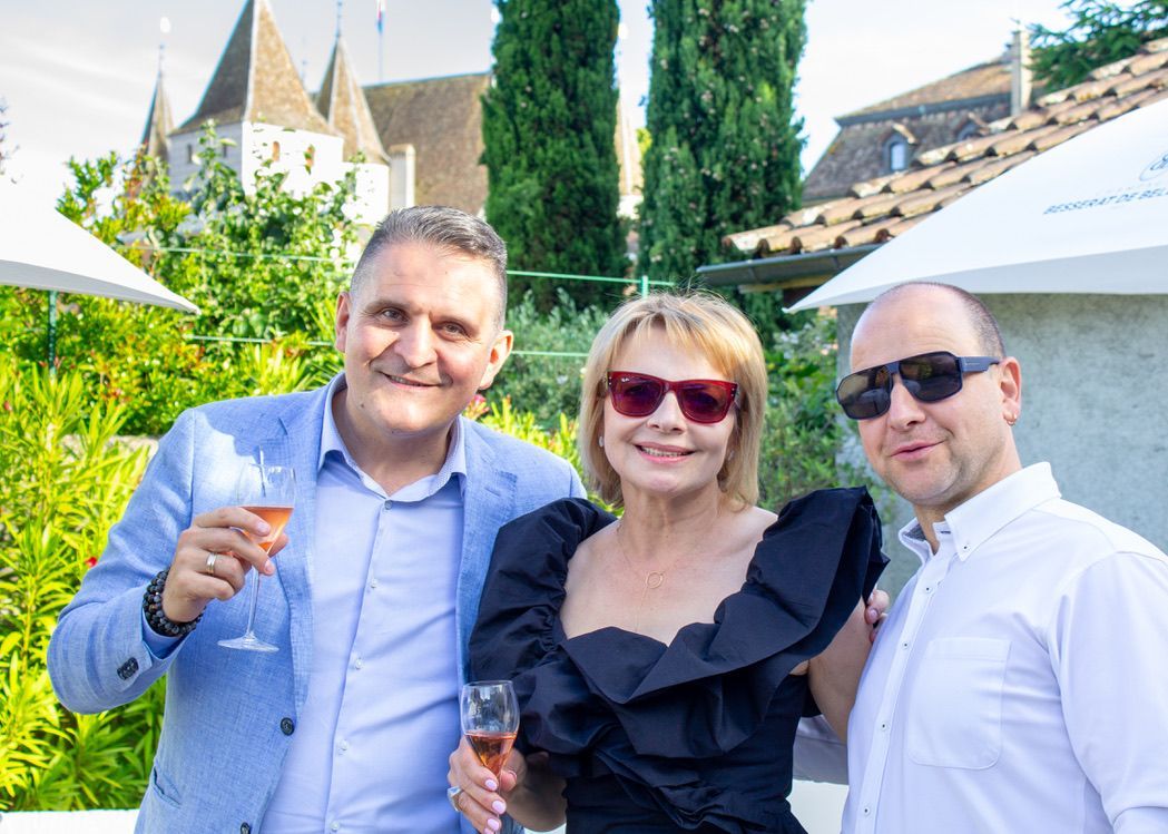 Un groupe de personnes pose pour une photo tout en tenant des verres à vin.