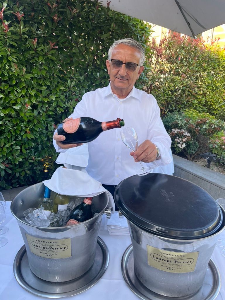 Un homme verse une bouteille de champagne dans un verre.