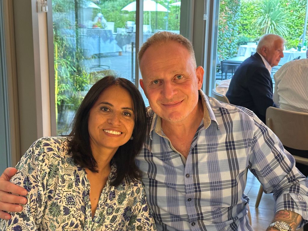 Un homme et une femme posent pour une photo assis à une table.