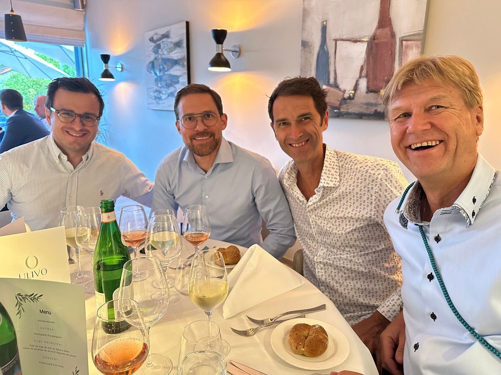 Un groupe d'hommes sont assis à une table avec des verres à vin.