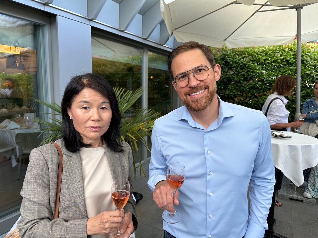 Un homme et une femme sont debout l'un à côté de l'autre, tenant des verres à vin.