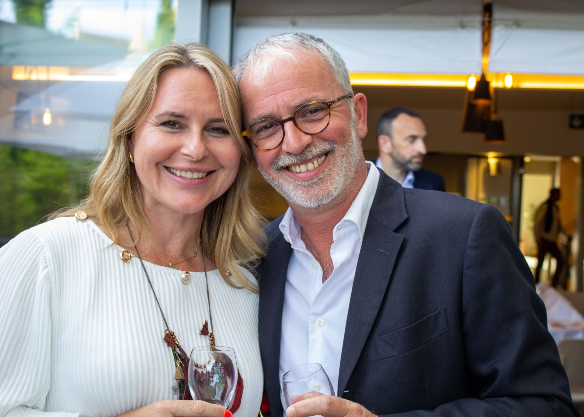 Un homme et une femme posent pour une photo tout en tenant des verres à vin.