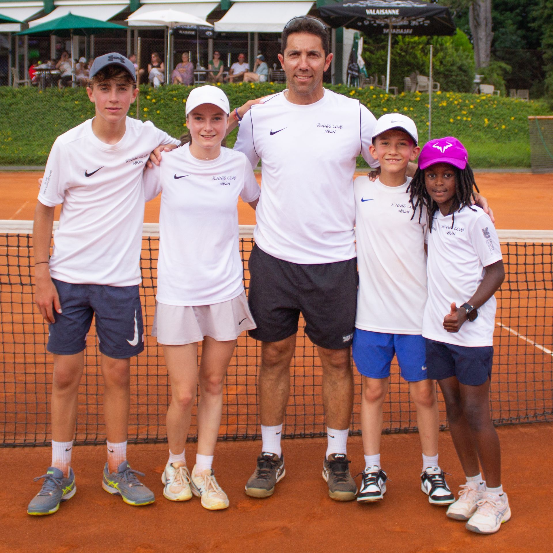 Un groupe de personnes posant pour une photo sur un court de tennis