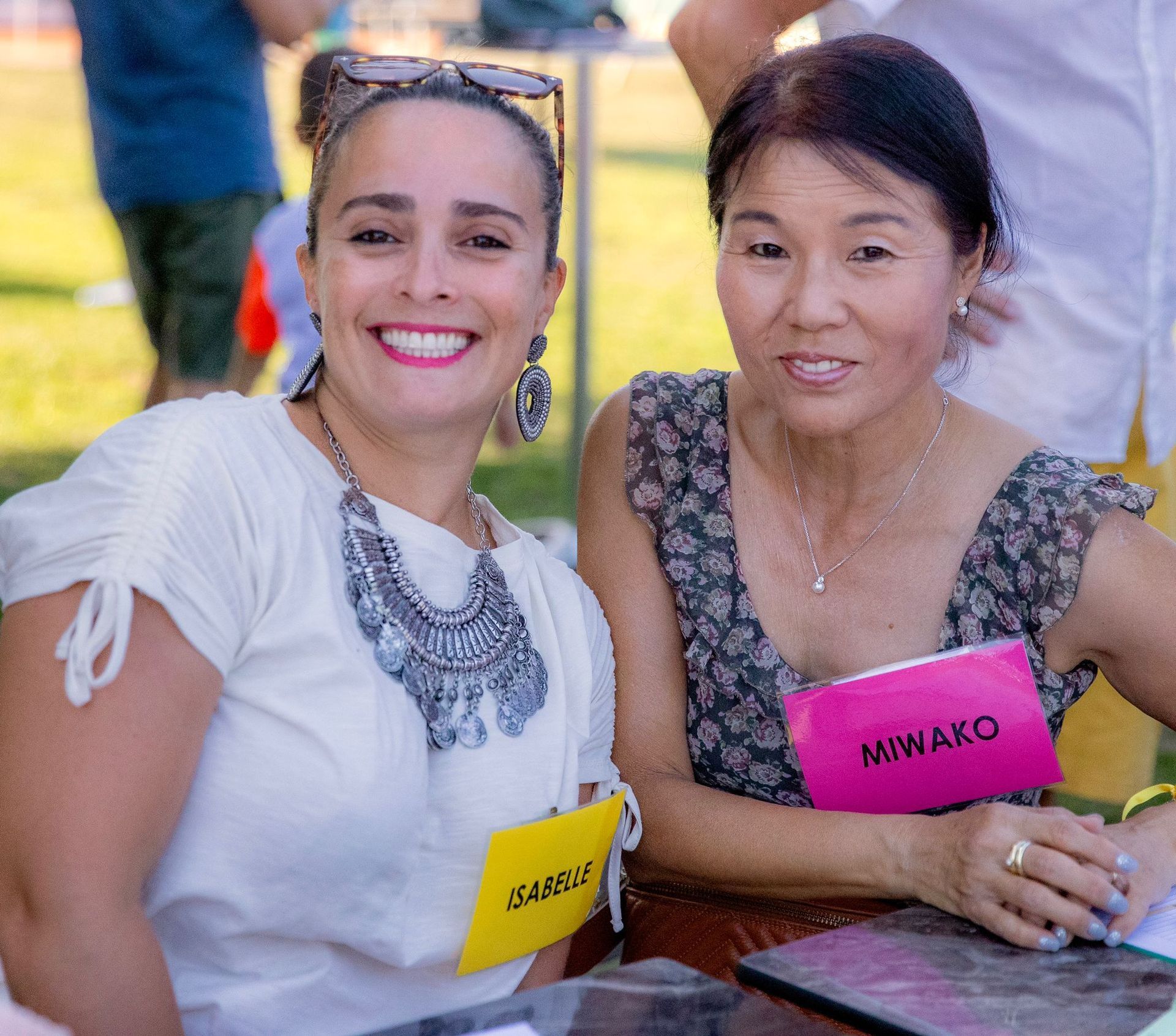 Deux femmes sont assises à une table avec une étiquette sur laquelle est écrit miwako