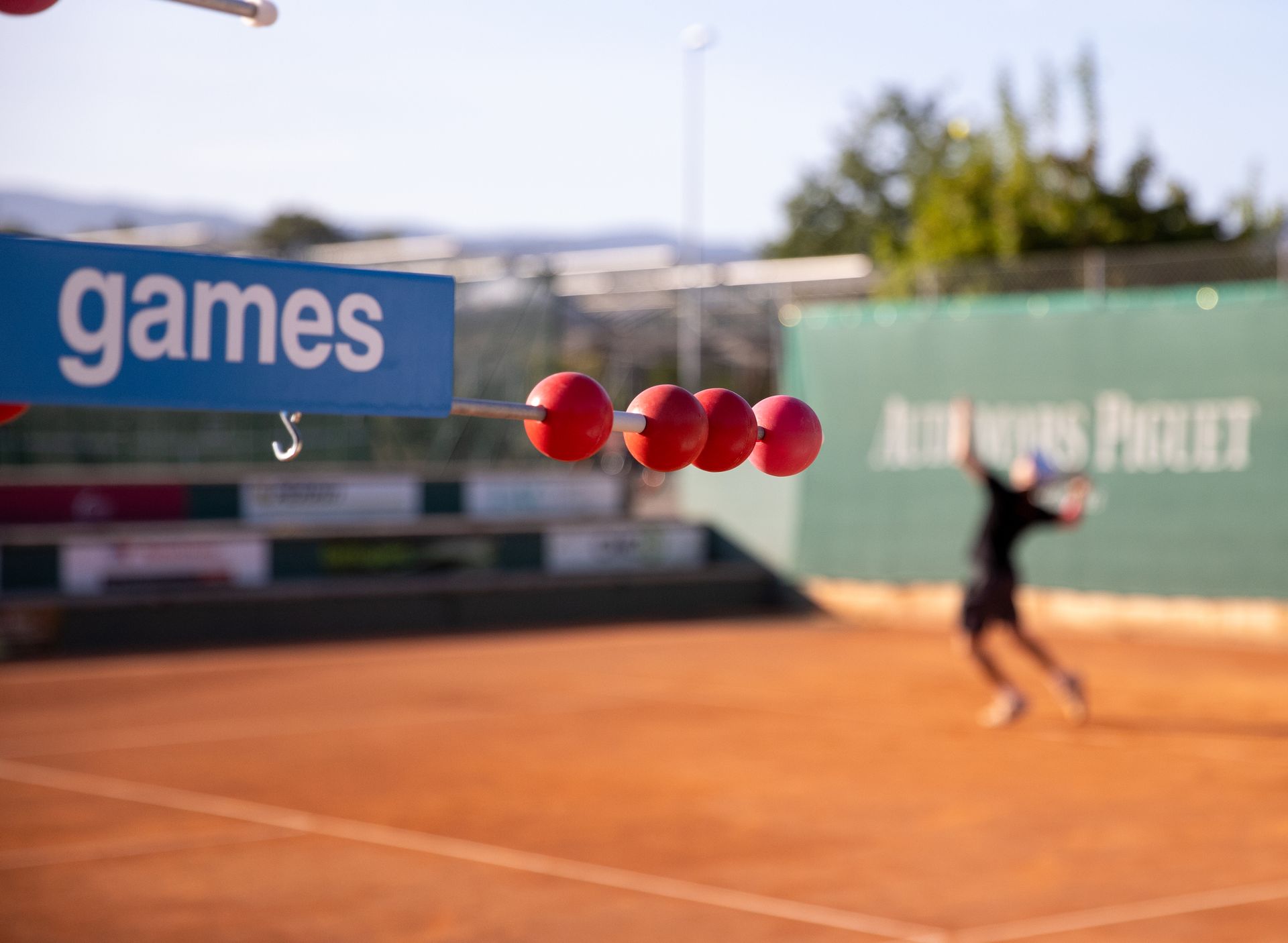 Un court de tennis avec un panneau indiquant des jeux dessus