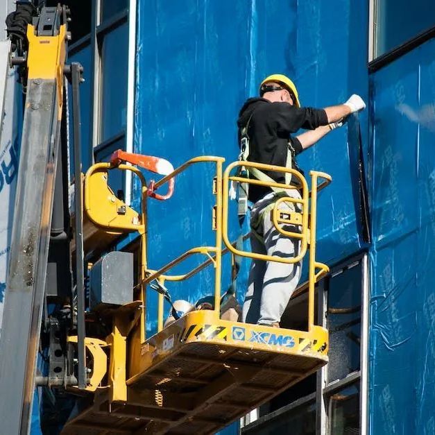 Un homme se tient debout dans un ascenseur XCMG jaune