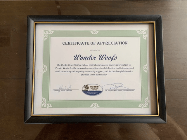 A framed certificate of appreciation for wonder woofs