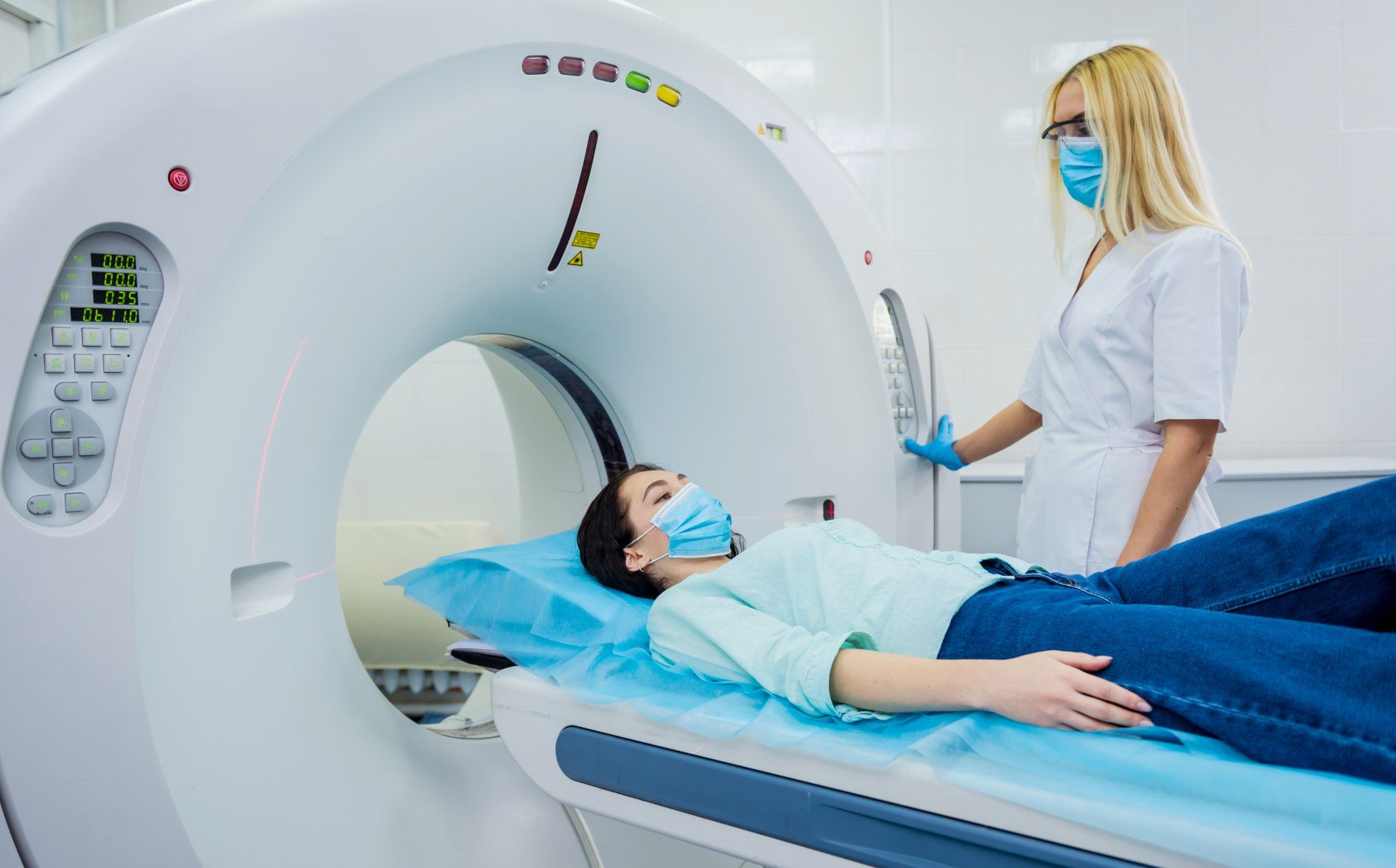 A woman is laying in a hospital bed getting a ct scan.