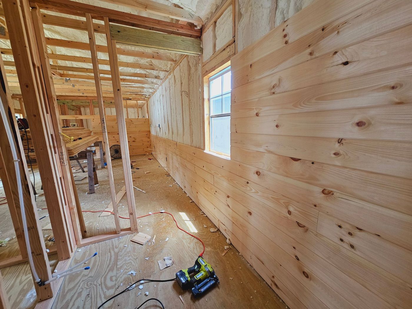 A wooden wall with a window in a house under construction.