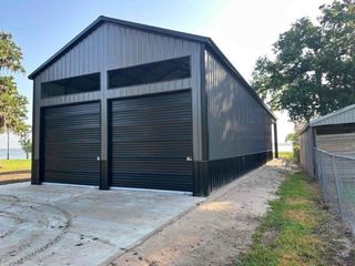 A large metal building with two black garage doors