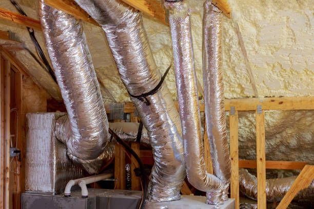 A bunch of ducts are hanging from the ceiling of a house.