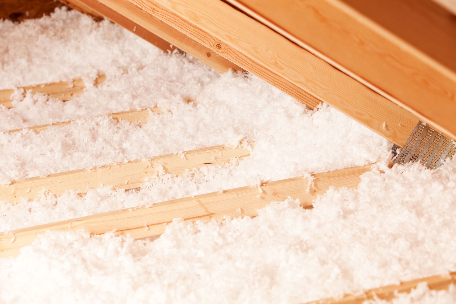 There is a lot of insulation in the attic of a house.