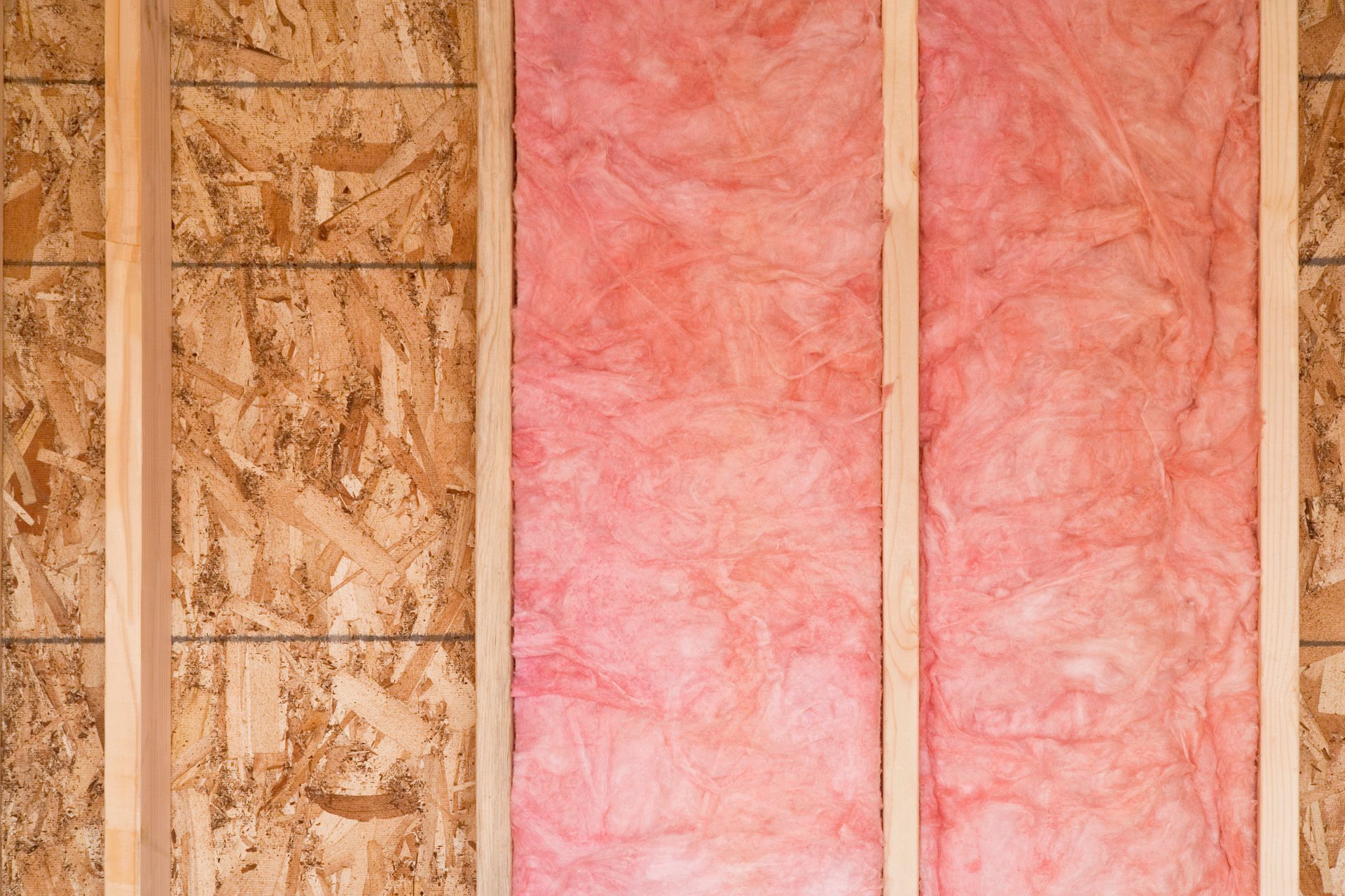 A close up of a wall with pink insulation on it.