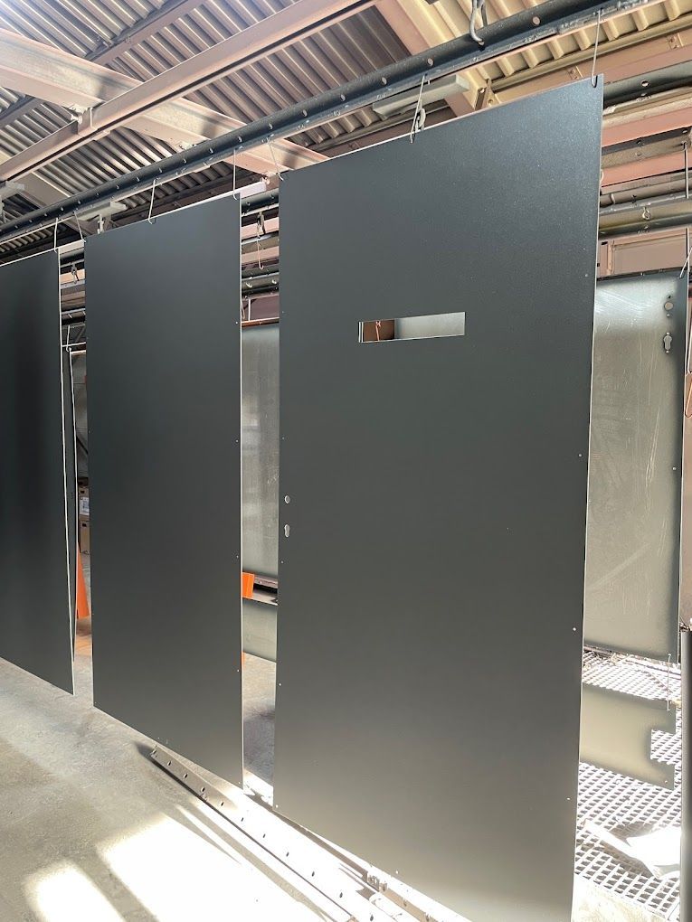 Eine Reihe übereinanderliegender schwarzer Türen in einem Lagerhaus.
