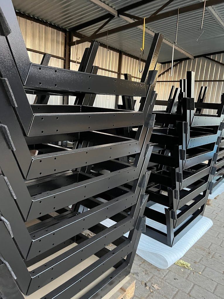 In einem Lagerhaus sind mehrere schwarze Metallkisten übereinander gestapelt.