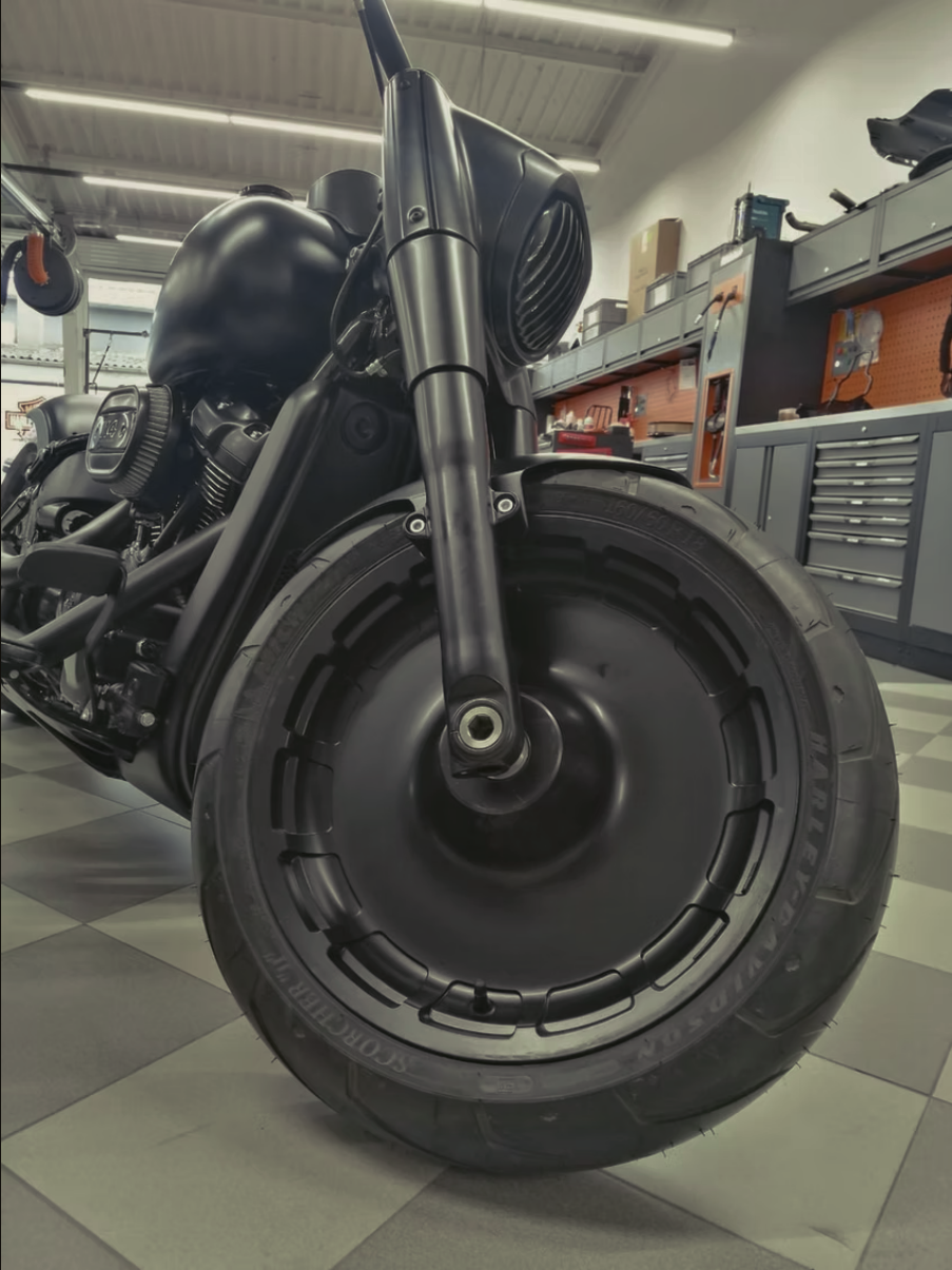 Ein schwarzes Motorrad in einer Werkstatt geparkt.