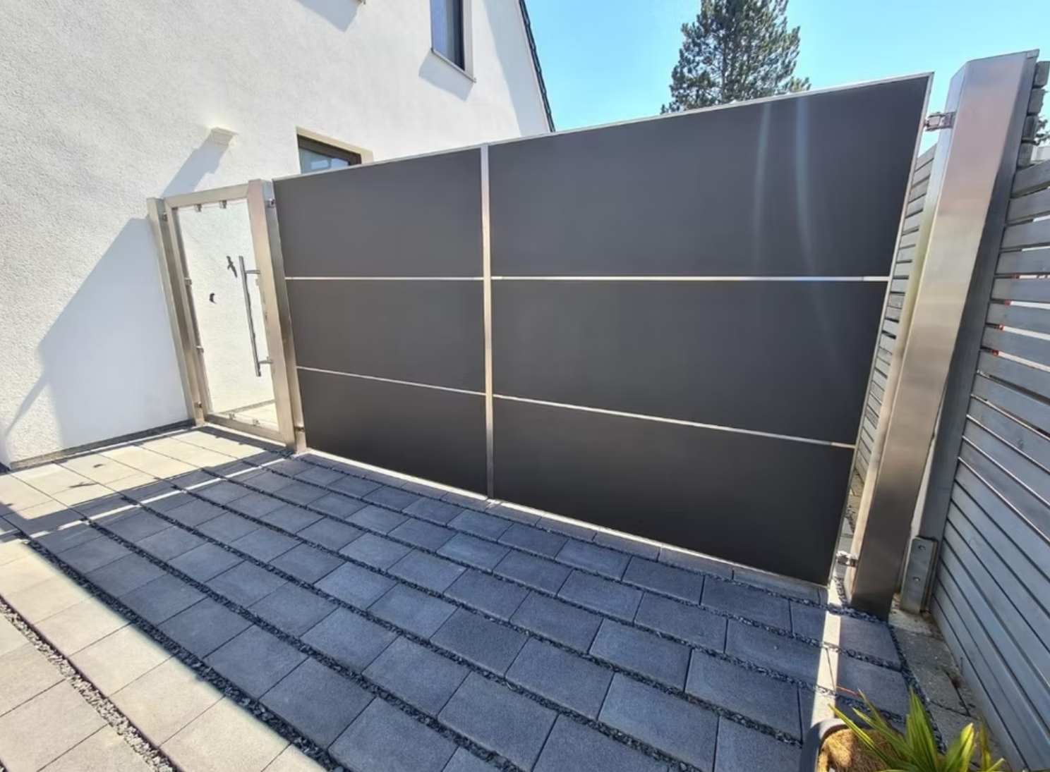 Ein schwarzer Zaun mit einem Edelstahlrahmen