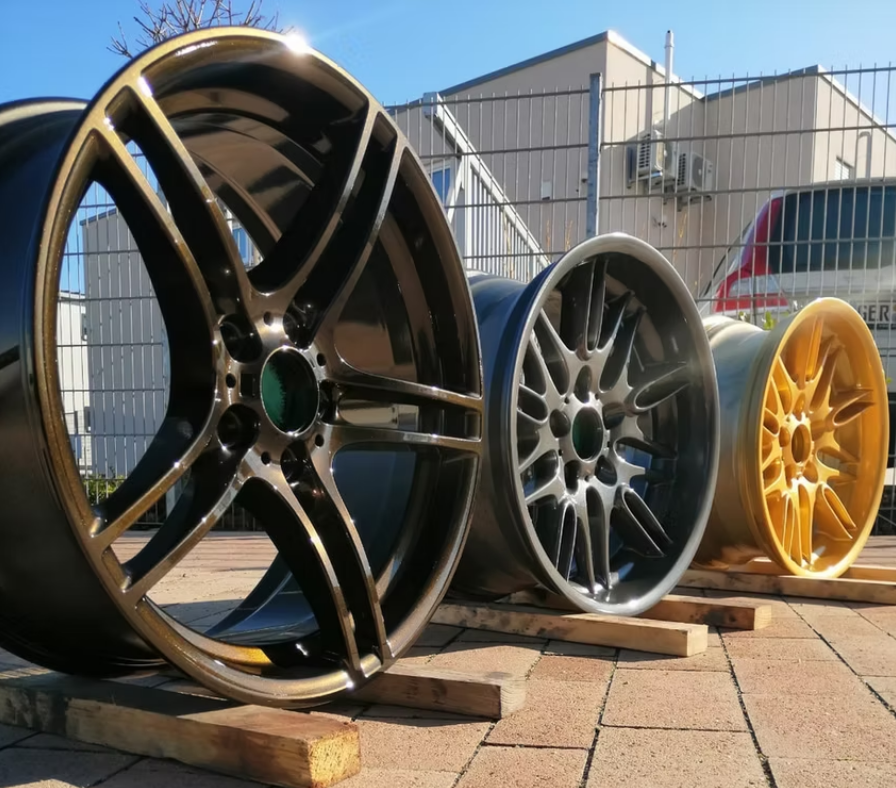 Drei verschiedenfarbige Räder sind auf einer Holzpalette aufgereiht