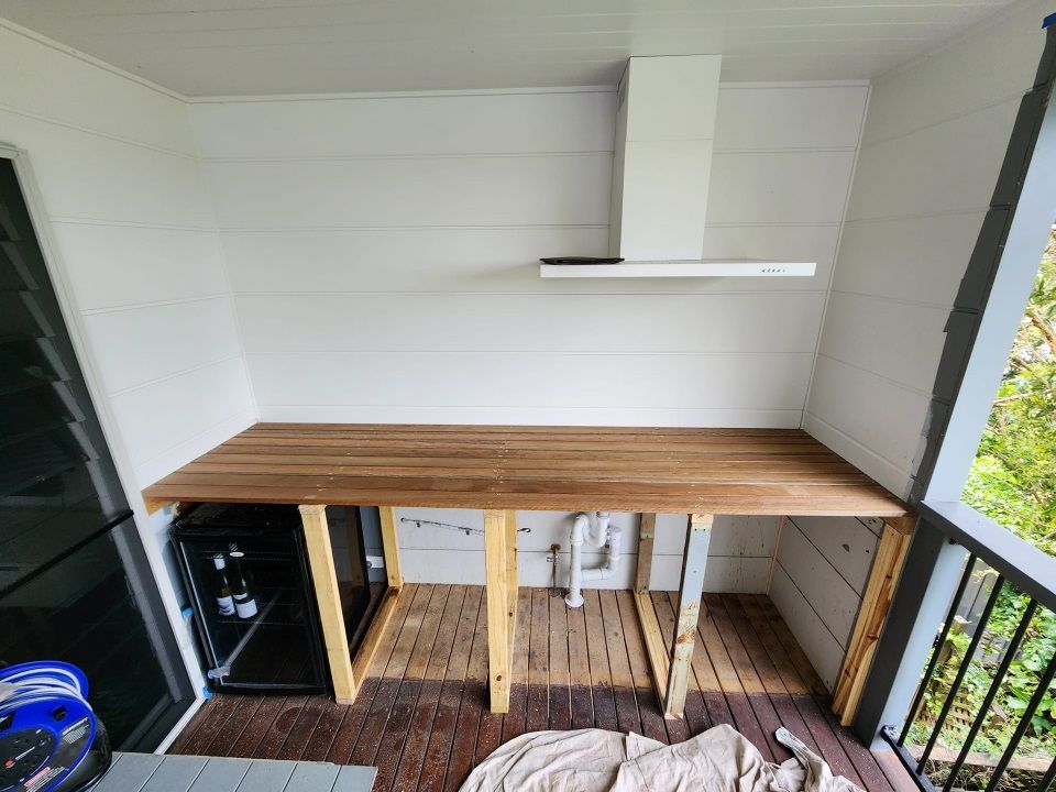 A Kitchen With a Wooden Table and a Hood Above It — Mark Cannon Carpentry & Maintenance in Moonee Beach, NSW