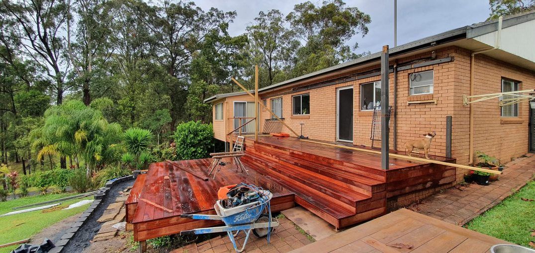 A Brick House With a Wheelbarrow in Front of It — Mark Cannon Carpentry & Maintenance in Moonee Beach, NSW