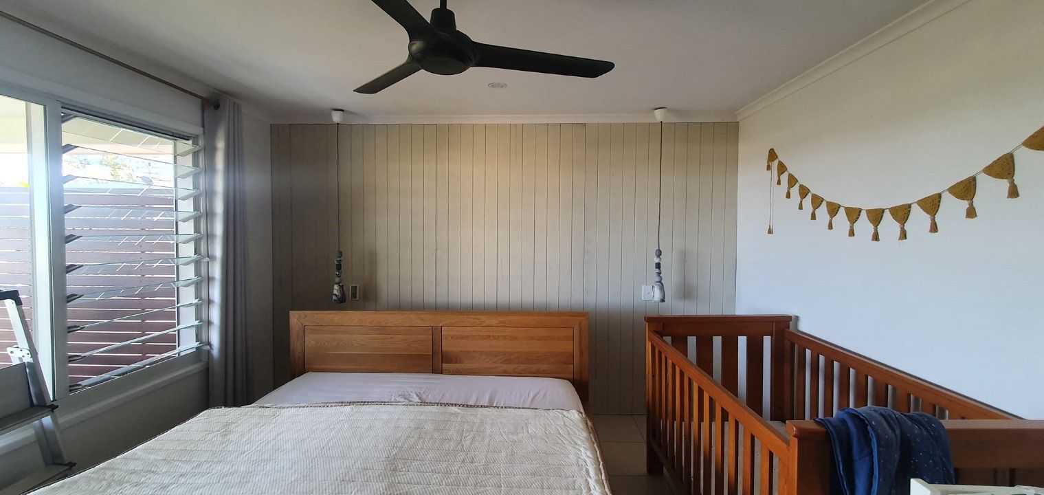 A Bedroom With a Bed and a Crib and a Ceiling Fan — Mark Cannon Carpentry & Maintenance in Moonee Beach, NSW