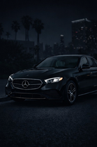 Black Mercedes-Benz sedan with a silver grill and wheels, angled slightly to the left.