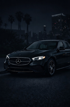 Black Mercedes-Benz sedan with a silver grill and wheels, angled slightly to the left.