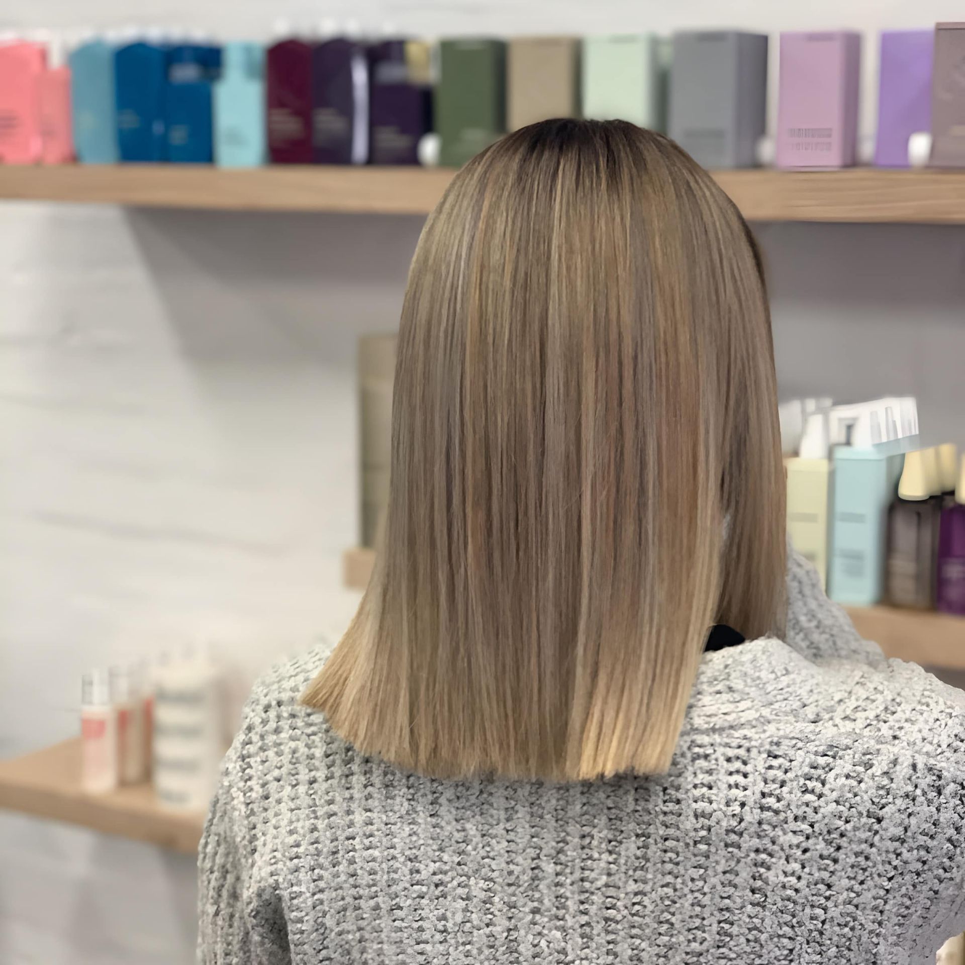 Woman With Long, Blonde, Straight Hair and a Dark Root, Standing in a Salon — Lavish Hair in Shepparton, VIC