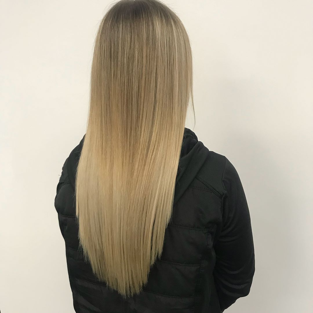 Woman With Long Blonde Hair Wearing a Black Jacket Against a White Wall — Lavish Hair in Shepparton, VIC