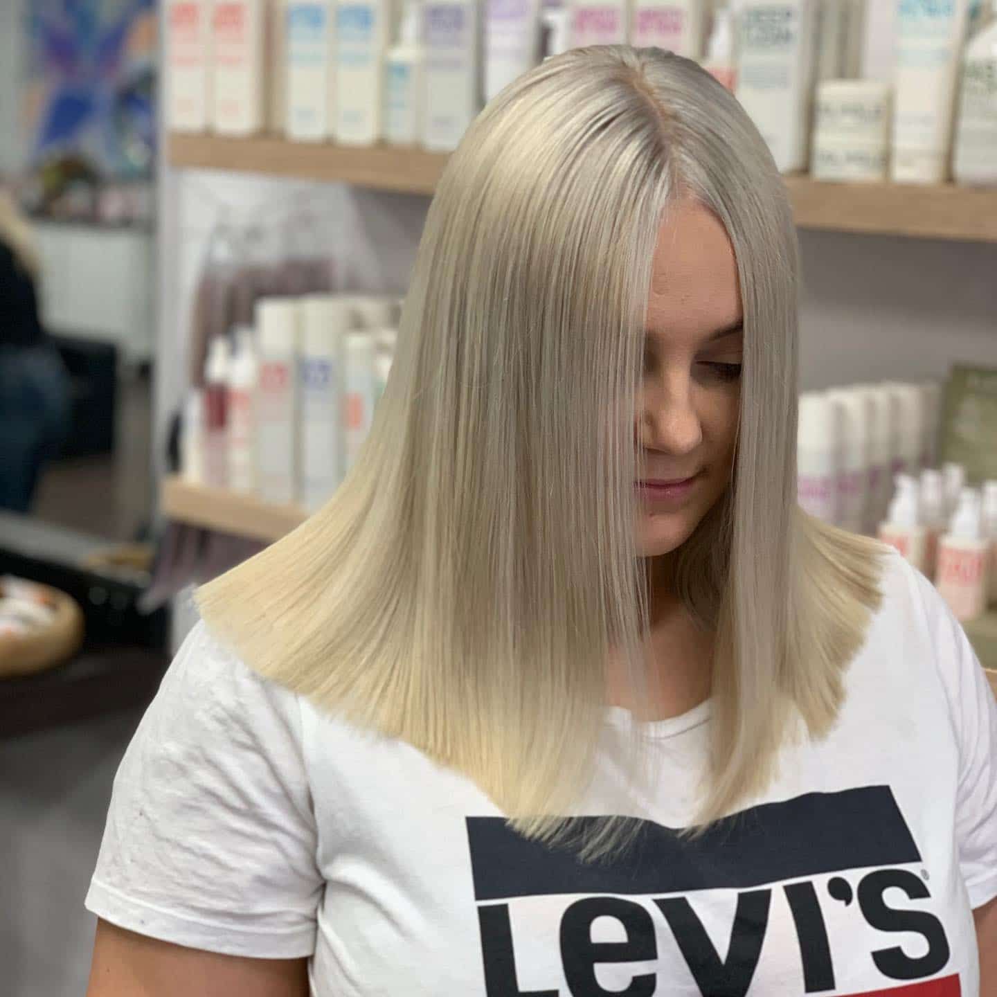 Woman With Straight, Light Blonde Hair, Wearing a White T-shirt — Lavish Hair in Shepparton, VIC