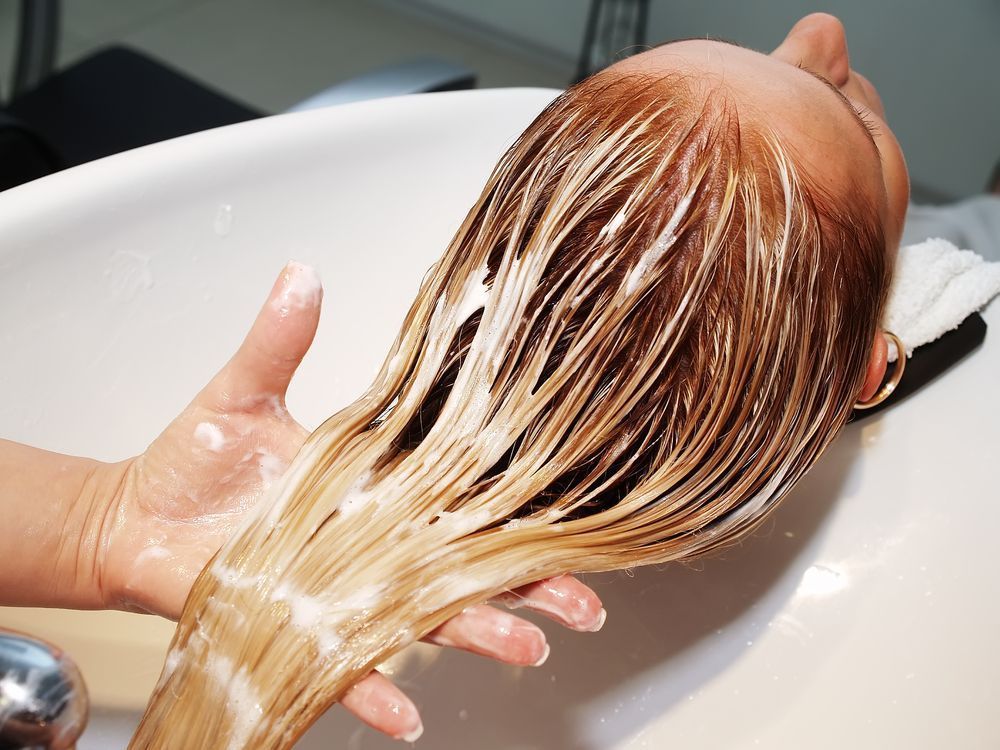 Person in a Salon With Hair Covered in Product, Being Held Over a Sink by a Stylist — Lavish Hair in Shepparton, VIC