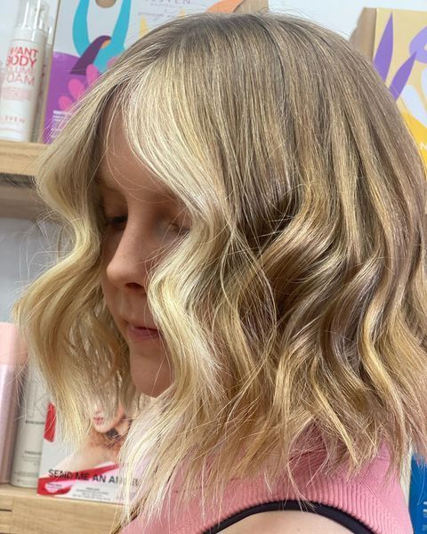 Woman With Wavy Blonde Hair and a Contrasting Lighter Blonde Section — Lavish Hair in Shepparton, VIC