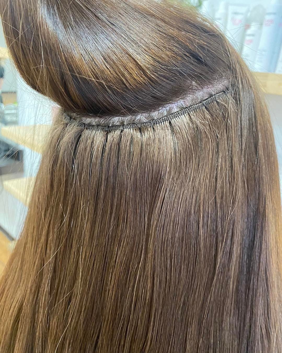 Close-up of Hair Extensions, Showing Dark Brown Hair Woven Together Near the Scalp — Lavish Hair in Shepparton, VIC