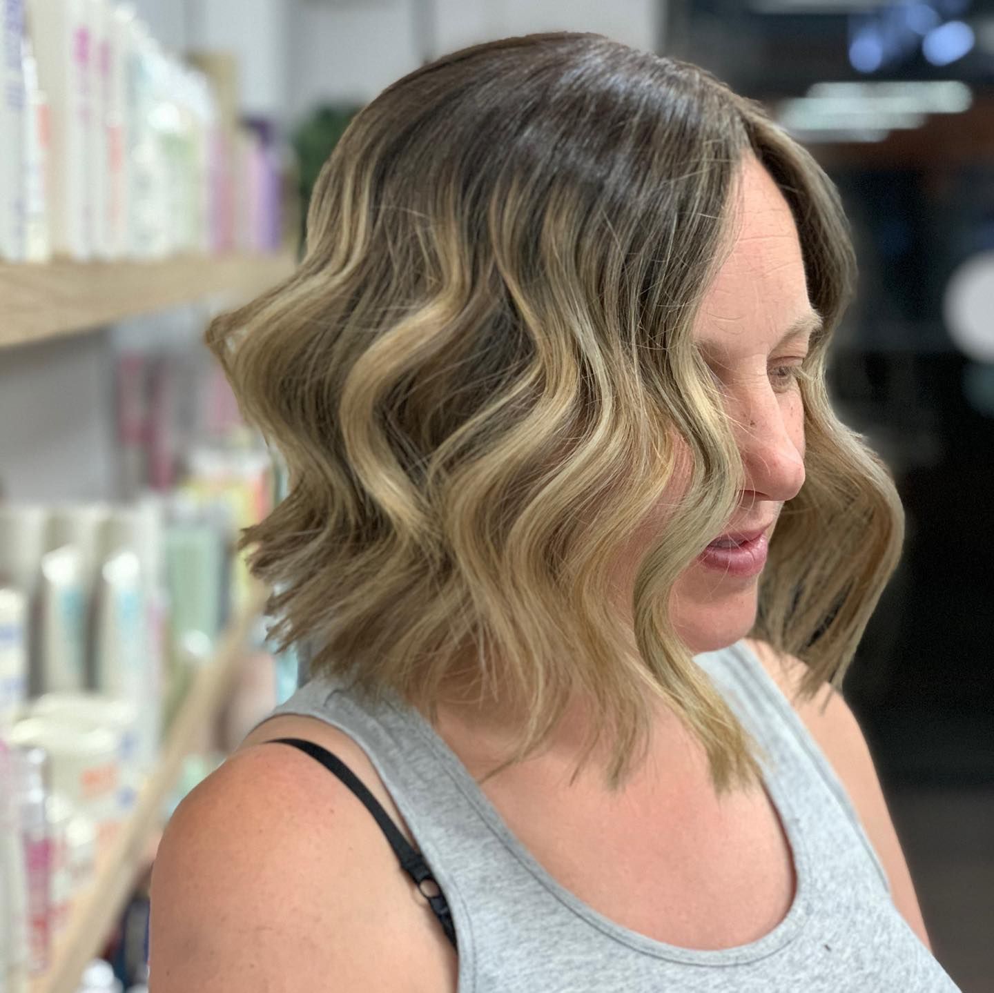 Woman With Wavy Blonde and Brown Hair, Wearing a Gray Tank Top, Smiling — Lavish Hair in Shepparton, VIC