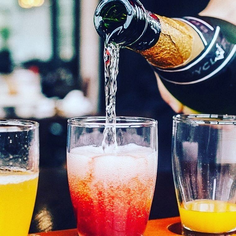 A person pouring a drink from a bottle that says vcla