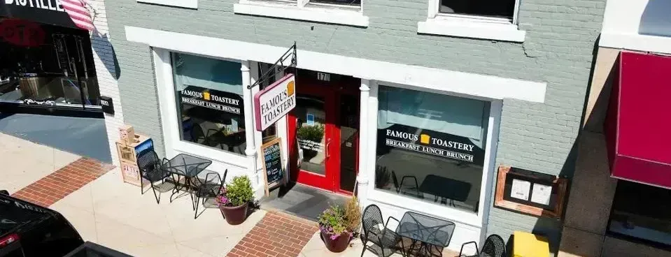 An aerial view of a restaurant with tables and chairs in front of it.