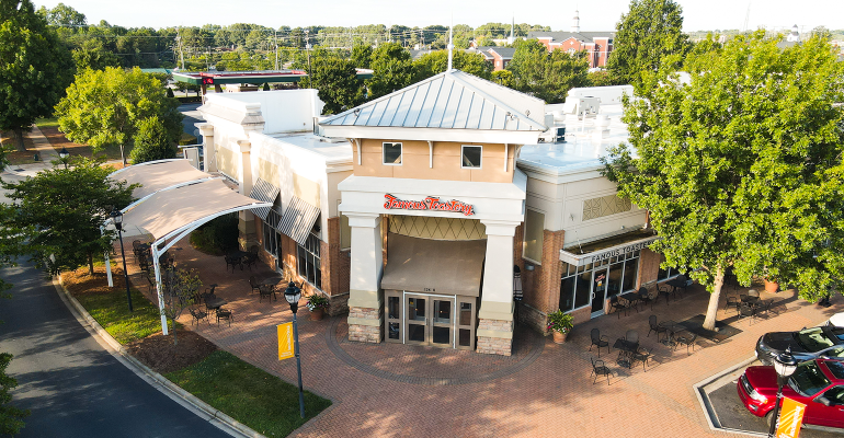 An aerial view of a restaurant with a red car parked in front of it.