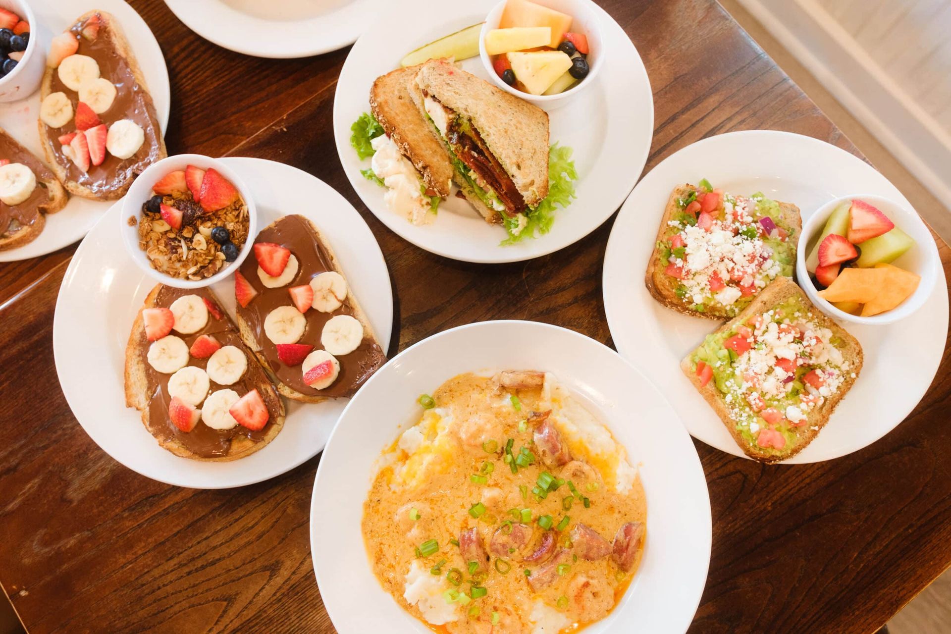 A table topped with plates of food and bowls of fruit.