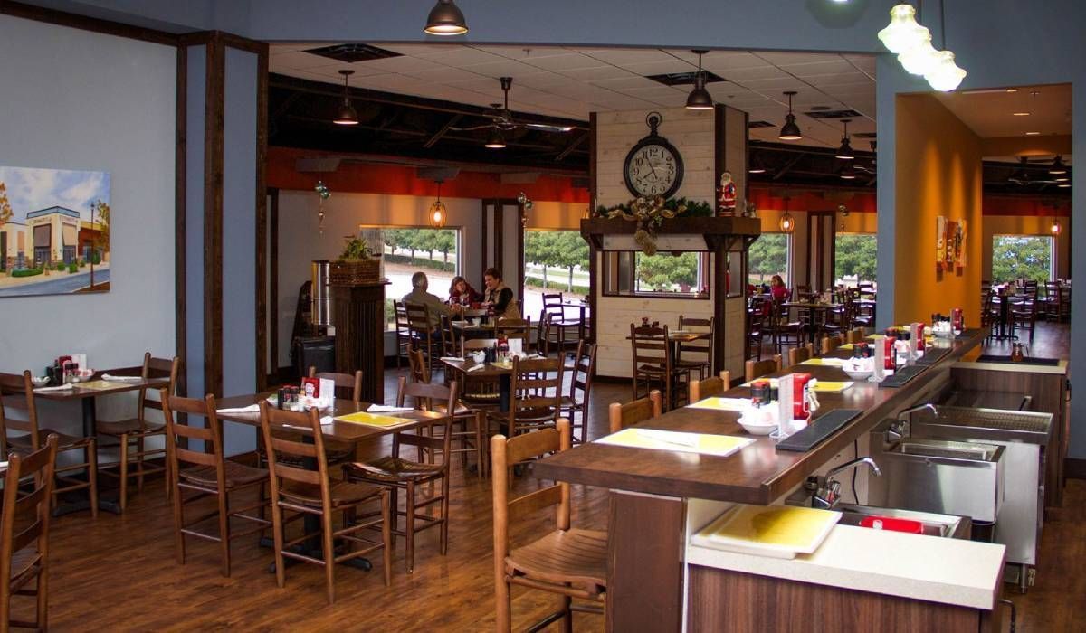 A restaurant with tables and chairs and a clock on the wall