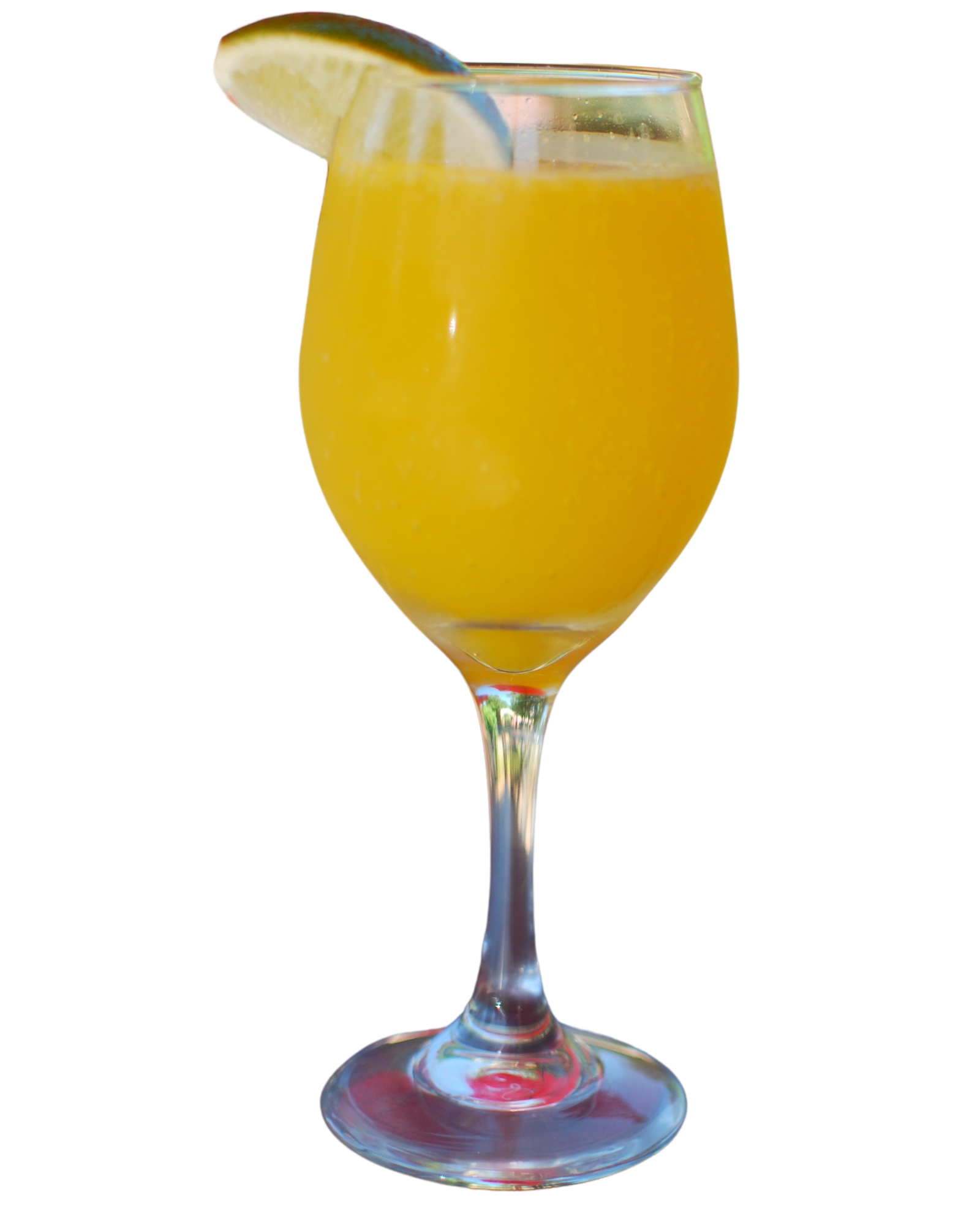 A glass of orange juice with a slice of lime on top.